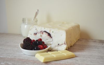 Trancio di gelato allo Yogurt variegato ai frutti di bosco, ricoperto di cioccolato bianco e granella di pistacchi. Servito a fette